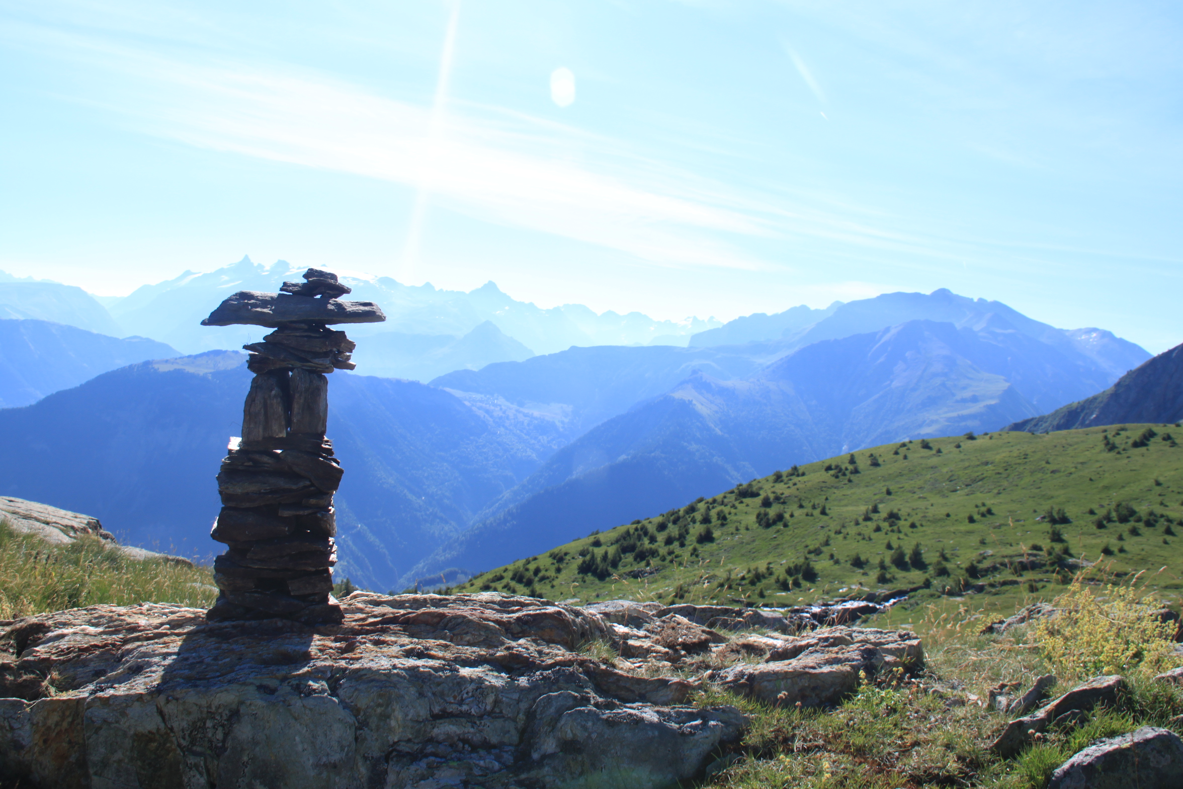 Cairn et panorama sur les Alpes depuis un sommet